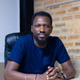Olugbenga Agboola, Flutterwave's CEO, sitting on a chair and looking into the camera